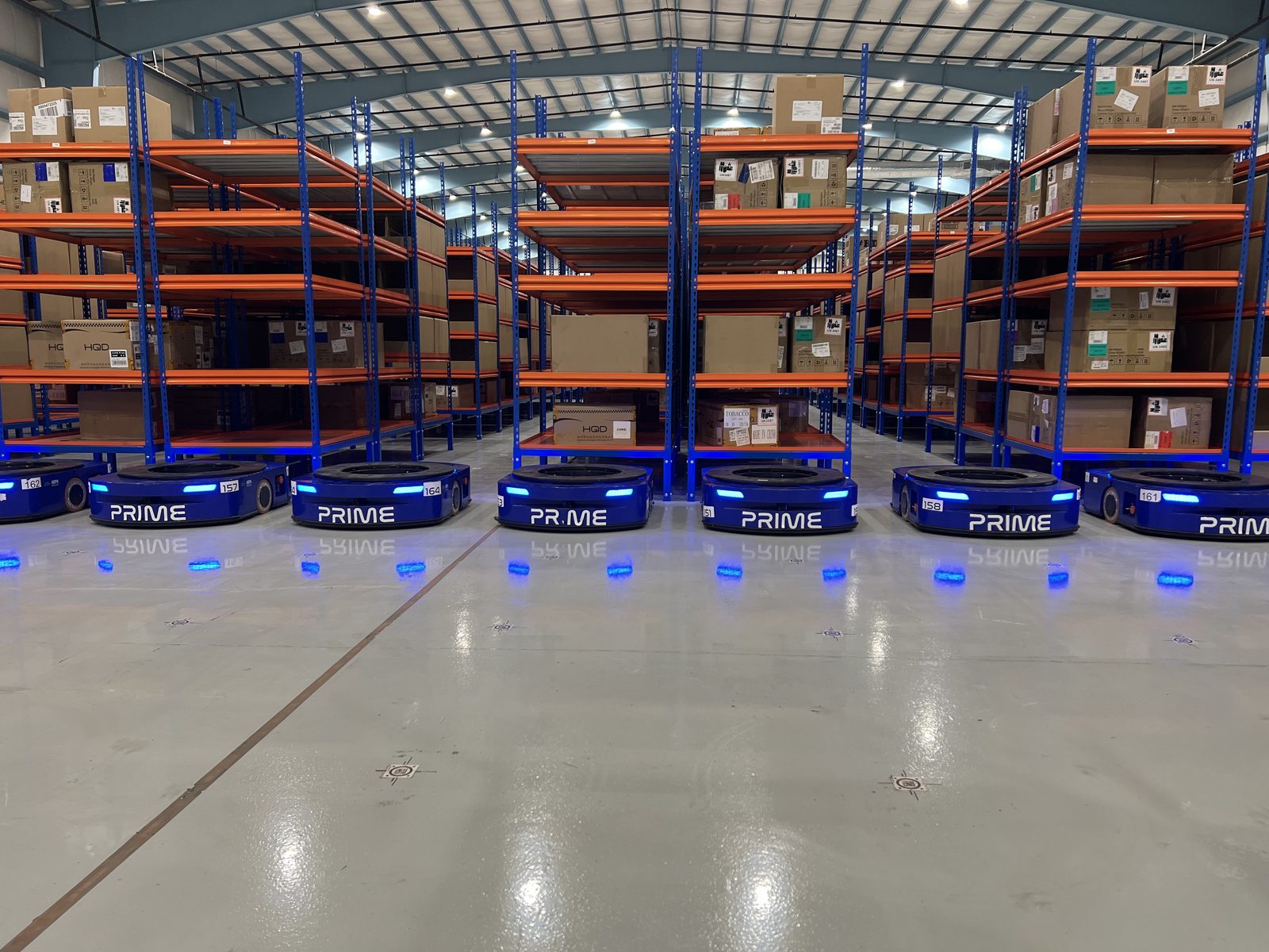 Two MobileShelf AMRs positioned under shelf units, ready to transport to picker stations